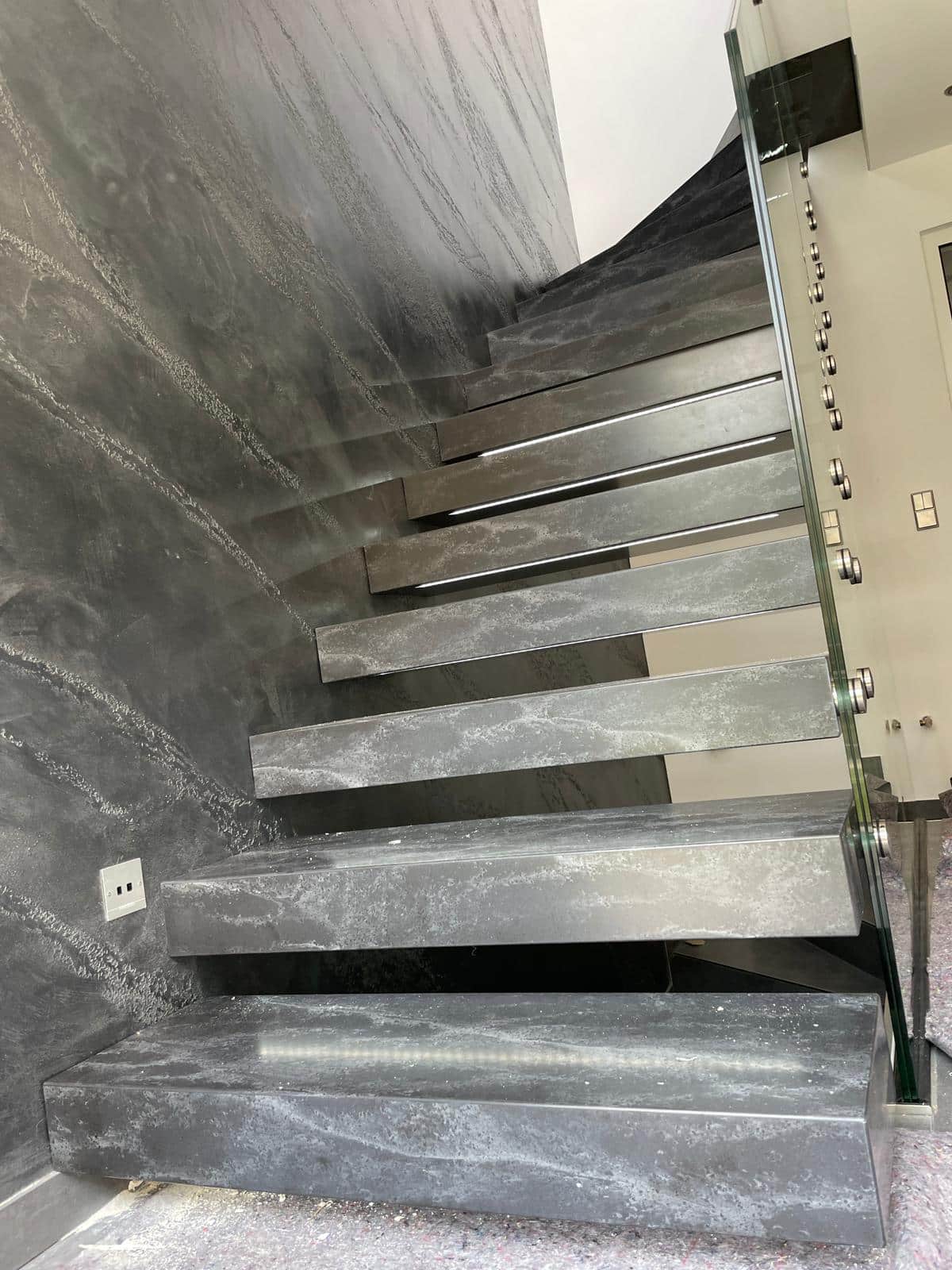 Kragarmtreppe Corian Stufen mit Glasgeländer